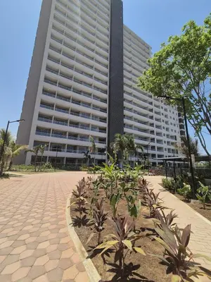a large building with palm trees in front of it at Seaside Retreat Beach Entrance 20th Floor in Santa Marta