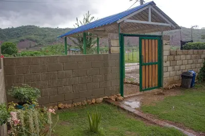 a brick wall with a colorful door in a yard at Hostal Cultural El Telar in San Jacinto