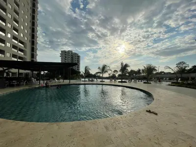 a large swimming pool in a courtyard with buildings at Apartamento Playa y piscina, Santa Marta in Santa Marta