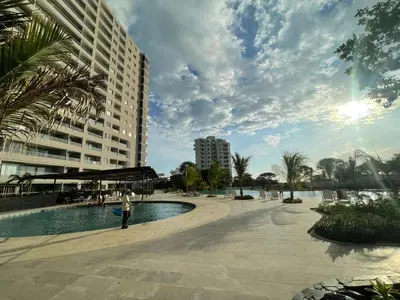 a person standing near a swimming pool in a city at Apartamento Playa y piscina, Santa Marta in Santa Marta