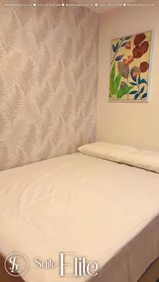 a bed in a room with a painting on the wall at Barranquilla Super Suite Elite in Barranquilla
