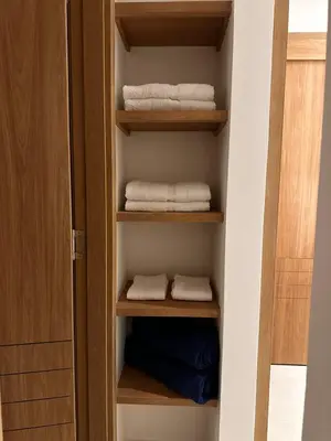 a closet with wooden shelves and white towels at Baia Kristal Andrés Cartagena in Cartagena de Indias