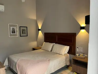 a bedroom with a bed and two lights on the wall at Casa Pozo del Carretero in Cartagena de Indias