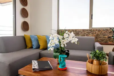 a living room with a couch and a table with flowers at Vita 902 Paraíso Costero in Cartagena de Indias