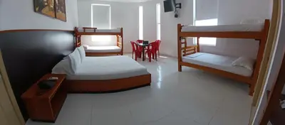 a bedroom with two bunk beds and a table and chairs at Hotel Boutique High Park in Cartagena de Indias