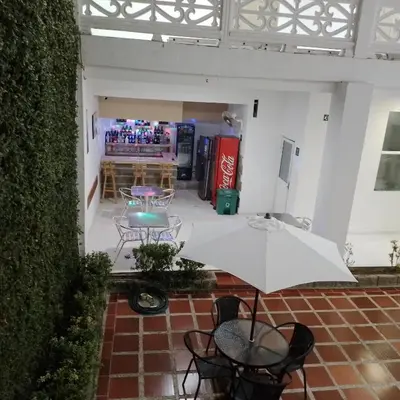a patio with a table and chairs and an umbrella at Hotel Boutique High Park in Cartagena de Indias
