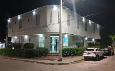 a white building with cars parked in front of it at Hotel Boutique High Park in Cartagena de Indias