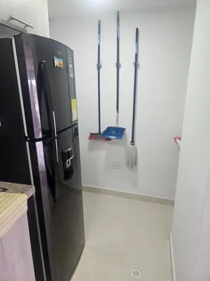 a refrigerator in a kitchen with mitts on the wall at Apartamento Moderno 2H cerca Aeropuerto, Playas y Centro Historico in Cartagena de Indias