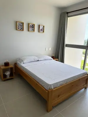 a bed in a bedroom with a large window at Baia Kristal Andrés Cartagena in Cartagena de Indias