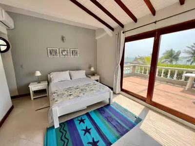 a bedroom with a bed and a balcony at Hermosa villa frente al mar in San Silvestre