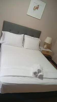 a bed with white sheets and pillows on it at Casa Cristi #5 in Cartagena de Indias