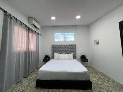 a bedroom with a white bed and a window at Family house colonial-style in Cartagena de Indias