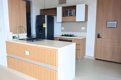 a kitchen with a white counter and a black refrigerator at Ultimo piso, amplia terraza y vista impresionante! in Los Arrayanes