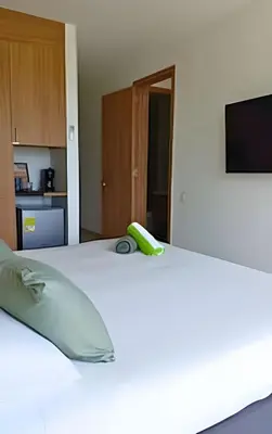 a white bed with a green phone on top of it at Ultimo piso, amplia terraza y vista impresionante! in Los Arrayanes