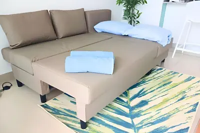 a brown couch with two pillows on a coffee table at Luxury Escape: Sea, Comfort & Style in Cartagena de Indias