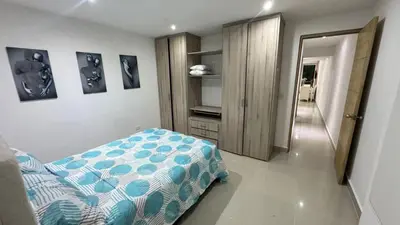 a bedroom with a bed with a blue and white comforter at Lindo Apartamento en la Boquilla BBB 4 pax in Cartagena de Indias