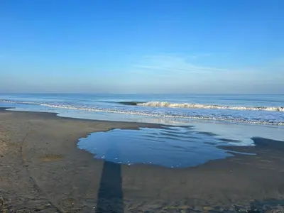 a reflection of a person standing on a beach at Cartagena 2 Hab con Terraza Privada Playa 12 min Parking in Manzanillo del Mar