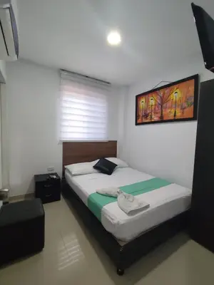a bedroom with a bed with a picture on the wall at Hotel Madeleine Norte in Barranquilla