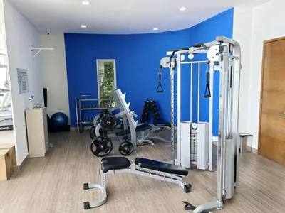 a gym with a blue wall and some equipment at Ikigai frente al mar con piscina infinita y Gym in Cartagena de Indias