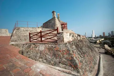 an old brick wall with a fence on top of it at City Tour por Cartagena con entradas in Cartagena de Indias