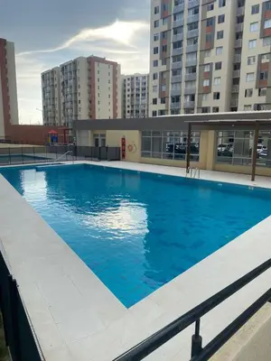 a large blue swimming pool with buildings in the background at Apartamento moderno para rentar por Días - Nuevo in Barranquilla