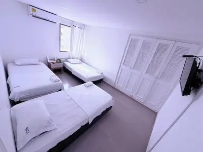a white room with two beds and a window at Ocean view apartment in a great location in Cartagena de Indias