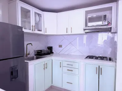 a kitchen with white cabinets and a black refrigerator at Ocean view apartment in a great location in Cartagena de Indias