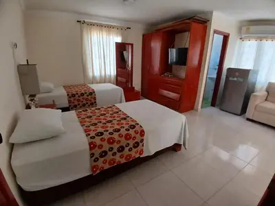 a hotel room with two beds and a television at Hotel Paseo Colon in Barranquilla