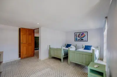 a bedroom with two twin beds and a door at La Dominica Hotel Boutique in Cartagena de Indias
