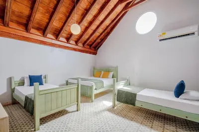 a bedroom with two beds and a wooden ceiling at La Dominica Hotel Boutique in Cartagena de Indias