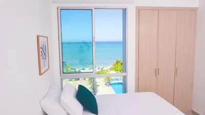 a bedroom with a view of the beach from a window at Magico Apartamento Frente al Mar 3 Habitaciones AR53 in Coveñas