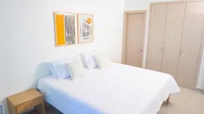 a white bedroom with a large white bed with pillows at Magico Apartamento Frente al Mar 3 Habitaciones AR53 in Coveñas