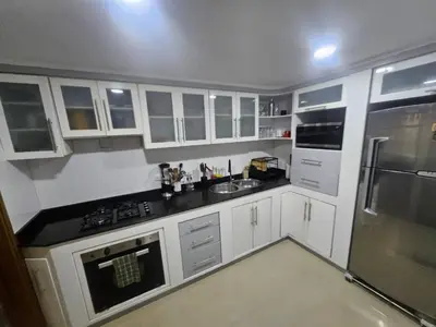 a kitchen with white cabinets and black counter tops at Guest House with AC, close to Historical Centre 3 in Cartagena de Indias