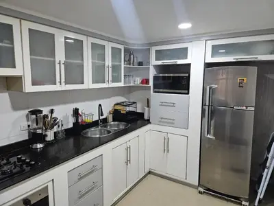 a kitchen with white cabinets and a stainless steel refrigerator at Guest House with AC, close to Historical Centre 1 in Cartagena de Indias