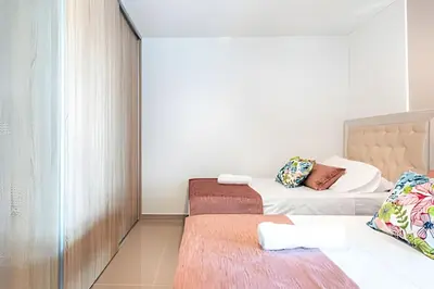 a small bedroom with two beds and a window at Exclusivo Duplex @Cabrero con Piscina & Parking in Cartagena de Indias