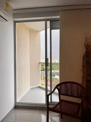a chair sitting in front of a large window at Vicmag House Barranquilla in Barranquilla