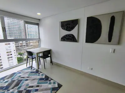a room with a table and two chairs and paintings at Apartamento en Edificio Magno Loft Apto DP 1001 in Cartagena de Indias