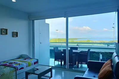 a living room with a dining table and a large glass window at Relax garantizado en Los Morros in Cartagena de Indias