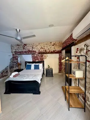 a bedroom with a bed and a brick wall at Casa Stephanie - Getsemani - Private pool in Cartagena de Indias