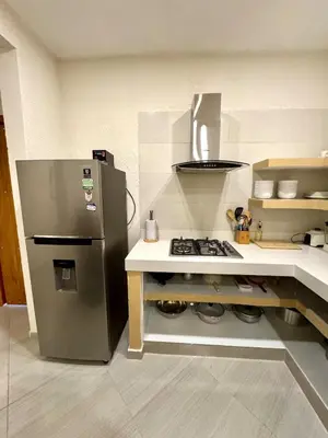 a small kitchen with a refrigerator and a stove at Casa Stephanie - Getsemani - Private pool in Cartagena de Indias