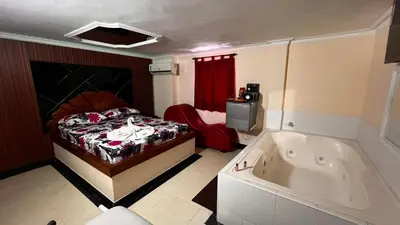 a bedroom with a bed and a tub in it at Hotel By Hours Jurassic in Barranquilla