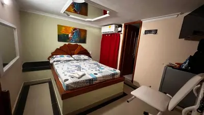 a small bedroom with a bed and a chair at Hotel By Hours Jurassic in Barranquilla