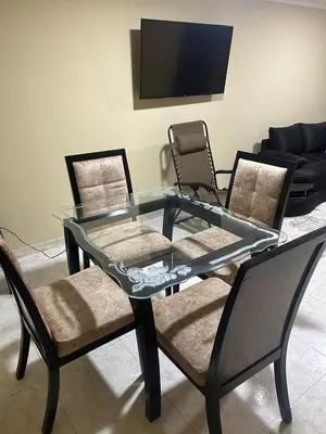 a glass table with two chairs and a tv at Apartamento Barrio San Jose Barranquilla in Barranquilla