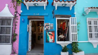 a blue building with white windows and a doorway at Art Hotel Getsemani in Cartagena de Indias