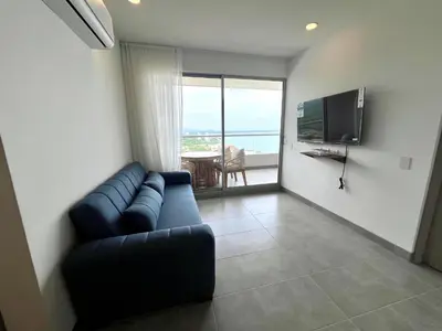 a living room with a couch and a television at Apartamento familiar en Santa Marta con vista al mar y la Sierra in Santa Marta