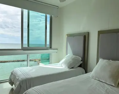 two beds in a room with a view of the ocean at Apartamento con vistas al Mar caribe in Coveñas