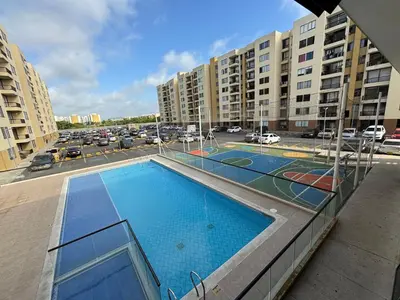 an apartment building with two tennis courts in a parking lot at Corazón de quilla in Barranquilla