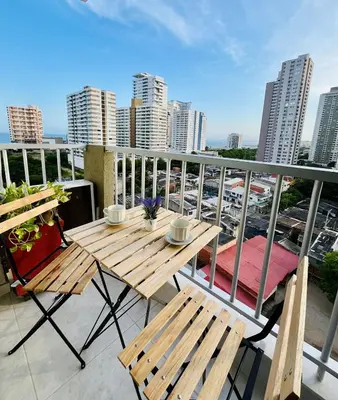 a table and chairs on a balcony with a view of a city at Beach Nearby Stunning Views Ultimate Comfort in Cartagena de Indias