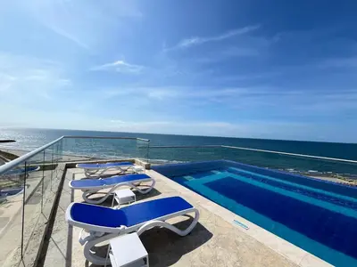 a balcony with lounge chairs and a swimming pool at Ocean Drive Cartagena Apto con Piscina Infinity in Cartagena de Indias