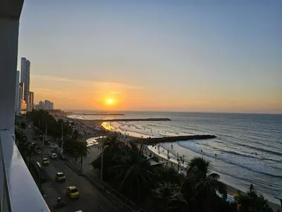a view of a beach at sunset with the ocean at Spacious beachfront apartment in Cartagena de Indias